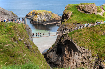 Tourist on the Carrick-a-Rede rope bridge on the Causeway Coast in Antrim County, Northern Irelandのeditorial素材