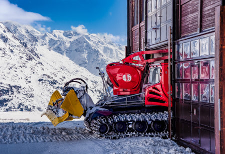 Red Snow groomer entering the garage in Austrian Alpsのeditorial素材