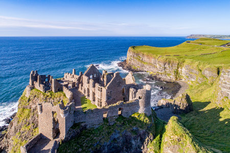 Ruins of medieval Dunluce Castle, cliffs, bays and peninsulas. Northern coast of County Antrim, Northern Ireland, UK.  Aerial view.のeditorial素材