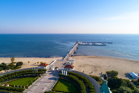 Sopot resort in Poland. Wooden pier (molo) with marina, yachts, beach, old lighthouse, walking people, vacation infrastructure, park and promenade. Aerial view at sunrise.の写真素材