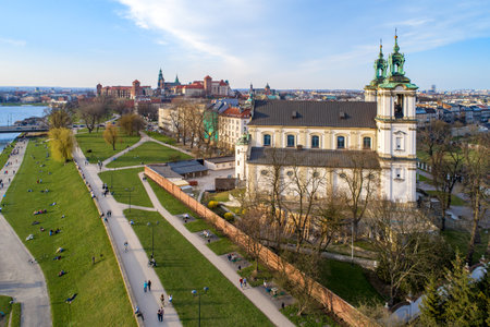 Krakow, Poland. Old city skyline, Paulinite monastery, Skalka church, far view of Wawel Cathedral and castle, Vistula River. People enjoying spring on the grass or walking. Aerial view, sunset lightのeditorial素材