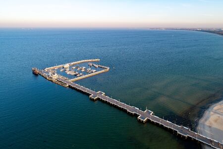 Sopot resort near Gdansk in Poland.  Wooden pier with harbor, marina with yachts and beach.  Aerial view in sunset light. Far view of Gdansk in the backgroundの写真素材