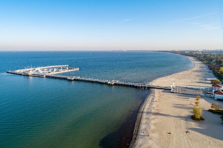 Wooden pier with harbor, marina with yachts and beach in Sopot resort near Gdansk in Poland in sunset light. Aerial view.の写真素材