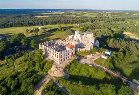 Rabsztyn, Poland. Ruins of medieval royal castle on the rock in Polish Jurassic Highland. Aerial view in sunrise light in summer. Renovation and archeological works in progressの写真素材