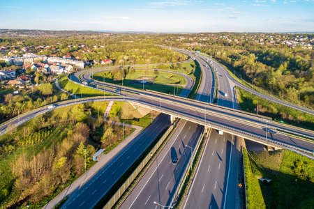 Motorway junction on A4 beltline around Krakow, Poland.  Overpass crossroad with slip roads, viaducts and traffic. Aerial viewの写真素材