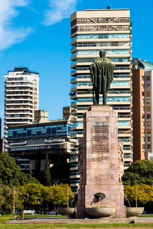Statue of a man looking to a building in a beautiful day in public park in Buenos Airesの写真素材