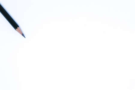 A Black Pencil in The Corner of Minimalist White Background with Flat Lay Shot, Landscape Mode
