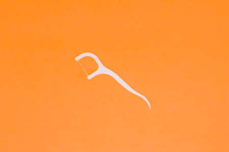 A White Dental Floss in The Orange Backrground with Flatlay Shotの写真素材