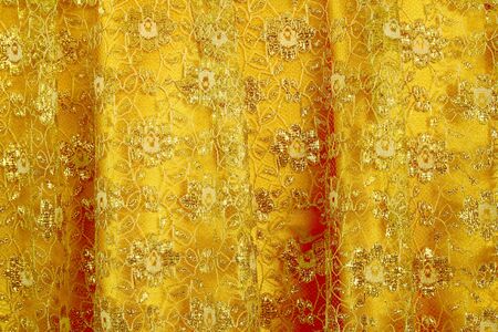 Gold peach lace sits on a gold silk backgroundの写真素材