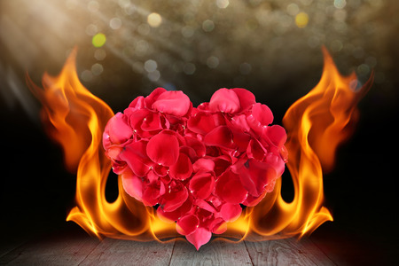 Rose petals heart shape with blaze fire flame on wooden deckの写真素材