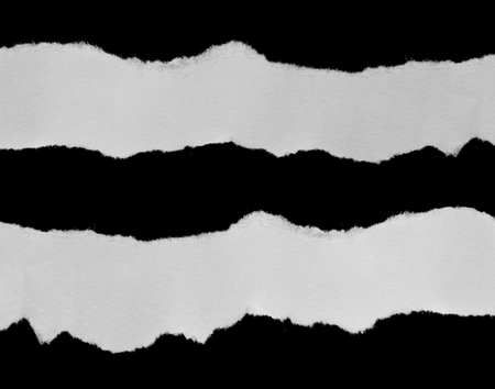 Piece of torn paper on blackの写真素材