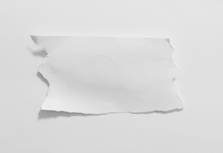 close up of a white ripped piece of paper on white backgroundの写真素材