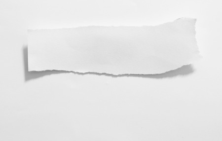 close up of a white ripped piece of paper on white backgroundの写真素材