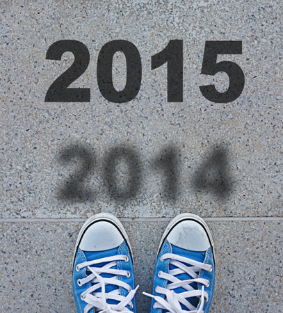 Sneakers standing on the asphalt with 2015 text on the groundの写真素材