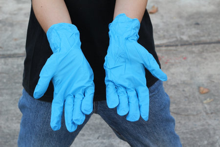 Hand in blue rubber gloves. Close up of female hands wearing blue rubber gloves.