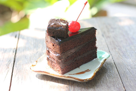 Chocolate cake with cherry on wooden background. Selective focus.
