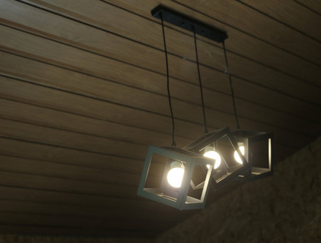 Ceiling lamp on wood wall background. Lighting equipment in loft style.