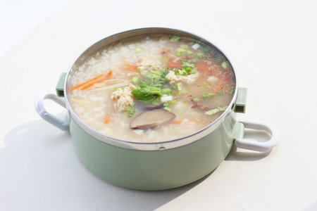 Porridge with chicken and vegetables in a pot on the tableの写真素材