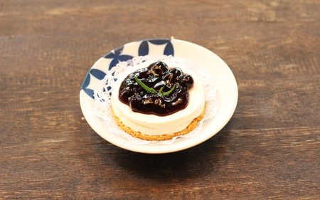 cheesecake with blueberry jam on a plate on a wooden backgroundの写真素材