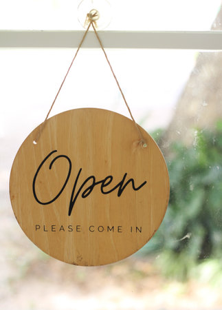 Wooden signboard on the glass door of the cafe with space for text