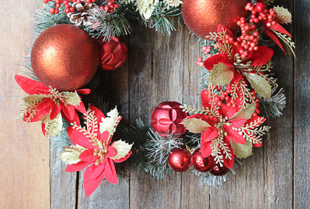 Christmas wreath with red and gold baubles on wooden backgroundの写真素材