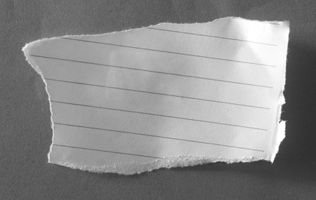 Piece of torn paper on plain grey background. Copy space.の写真素材