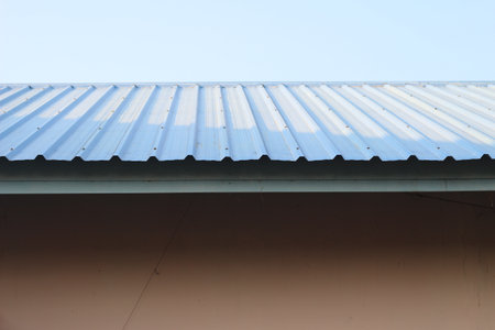 The roof of a building is covered with blue corrugated sheet metal.の写真素材