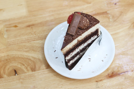 Chocolate cake with strawberry on top on wooden table background. Selective focus.