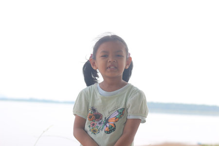 Portrait of asian little girl looking at camera on the beach
