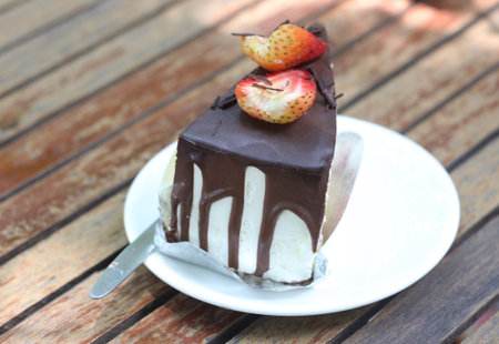 Chocolate ice-cream cake with strawberry on top on wooden table