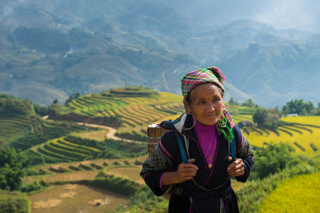 SAPA - SEP 13 : Unidentified Old Hmong woman with rice field terrace background on September 13th, 2014 in Sapa, Vietnamのeditorial素材