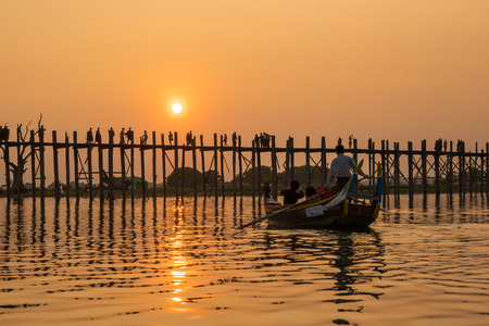 Silhouetted people on U Bein Bridge at sunset, Amarapura, Mandalay region, Myanmarの写真素材