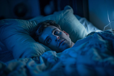 Sleepless Man In Bed Plagued By Insomnia, Feeling Down And Restless Standard. Concept Sleeplessness, Insomnia, Feeling Down, Restlessness.の素材