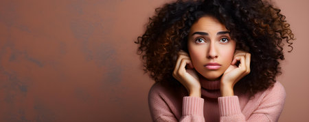 Anxious Hispanic woman with curly hair feeling stressed over a problem on pink background. Concept Portrait Photography, Emotions, Hispanic Culture, Anxiety, Stressの素材