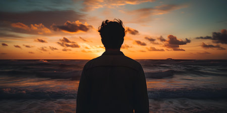 Contemplation by the ocean: A silhouette of a man at sunset. Concept Nature, Ocean, Sunset, Silhouette Portrait, Contemplationの素材