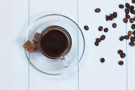 Espresso cup of coffee, sugar and beans on a wood tableの写真素材