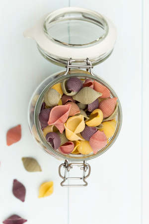 Raw cocciolette pasta on a glass jar on blue wood tableの写真素材