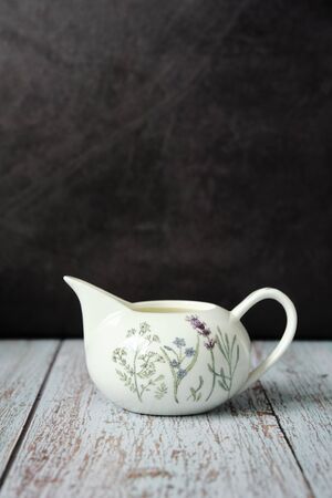 Detail of a pitcher full of fresh milk on wooden table with dark background and copy spaceの写真素材