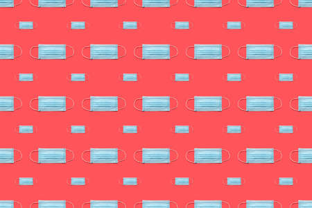 Disposable surgical face mask on red background.  Healthcare and medical concept. Seamless medical patternの写真素材