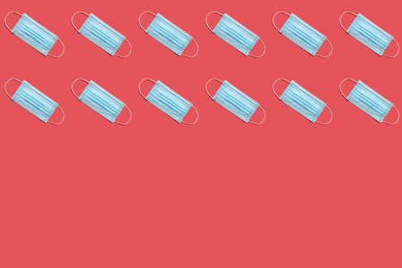 Disposable surgical face mask on red background.  Healthcare and medical concept.の写真素材