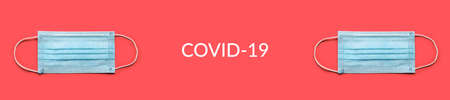 COVID-19 disposable surgical face mask on red background. Protection against coronavirus. Healthcare and medical concept. COVID-19 textの写真素材