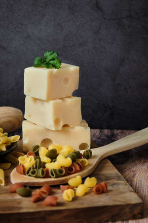 Different raw uncooked Italian pasta and cheese on wooden table. Diet and food concept.の写真素材