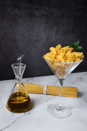 Different raw uncooked Italian pasta and cheese on wooden table. Diet and food concept.の写真素材