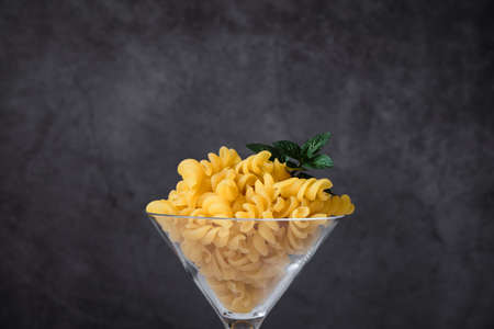 Different raw uncooked Italian pasta and cheese on wooden table. Diet and food concept.の写真素材