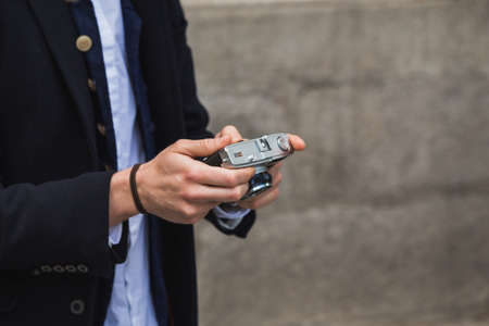 Portrait of young trendy man in the city looking to vintage film cameraの写真素材