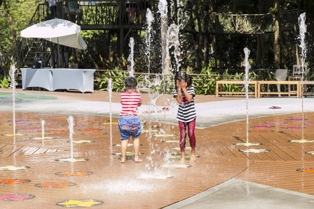 Children are having fun playing fountain outdoor, even in the sunlight.の写真素材