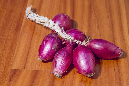 Pink Italian onion braid on wood backgroundの写真素材
