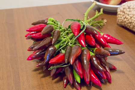bunch of chillies on wooden kitchen table with chickpeasの写真素材