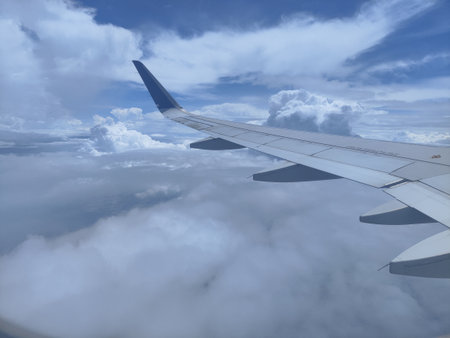Clouds and blue sky as seen through window of an aircraft.