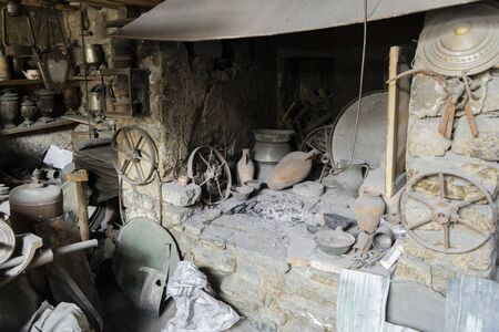Toolmakers or metal craftsmans workshop with copper container or vintage pots.
